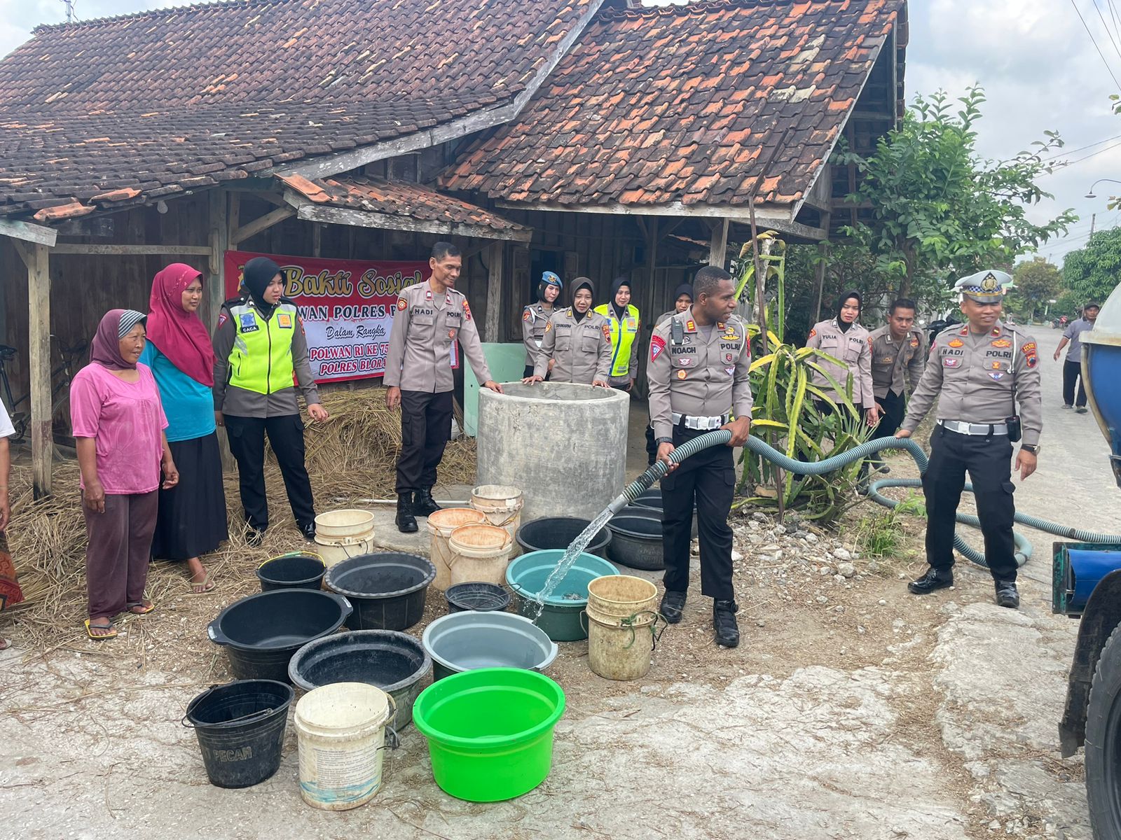 Kasatlantas Polres Blora saat menyalurkan air bersih bagi warga terdampak kekeringan, Senin (19/6/2023).