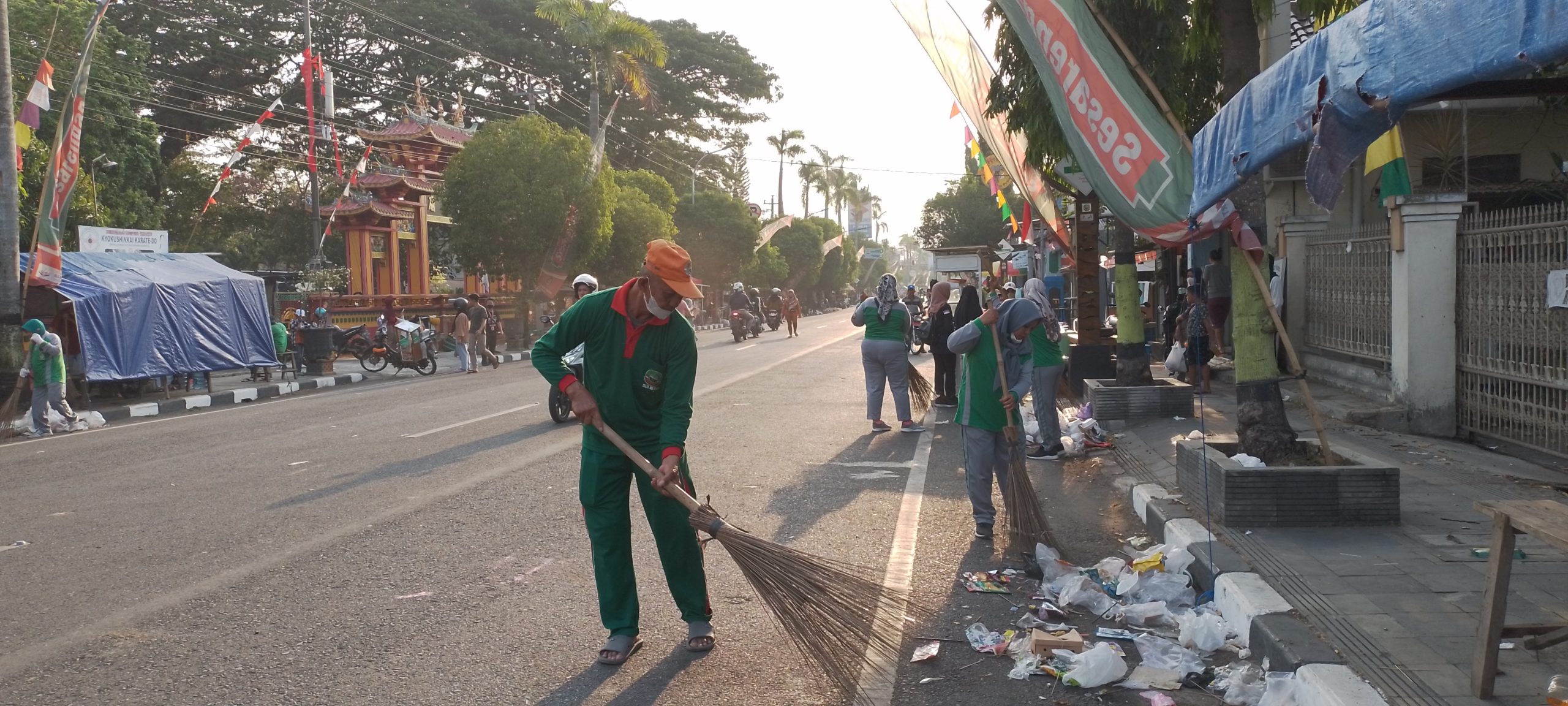 Petugas kebersihan DLH Blora saat membersihkan sampah di sepanjang Jalan Pemuda Blora, usai karnaval, Sabtu (26/8).