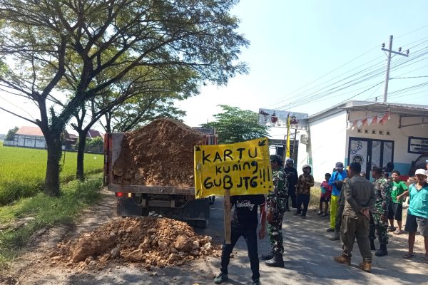 Ratusan warga Randublatung menggelar aksi protes dengan menguruk jalan menggunakan grosok serta menanam pohon pisang di ruas Jalan Randublatung–Cepu, Minggu (31/5/2026).